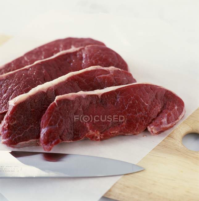 Кусочки говядины с ножом — стоковое фото