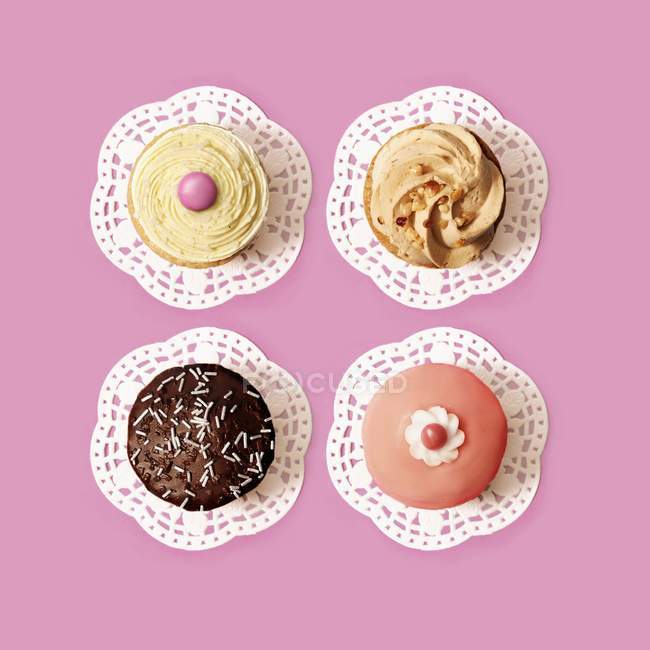 Cupcake assortiti su superficie rosa — Foto stock