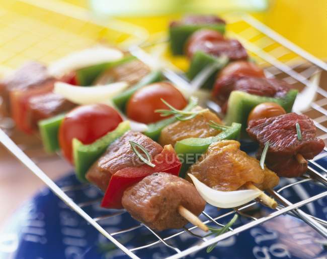 Meat kebabs on wire rack — Stock Photo