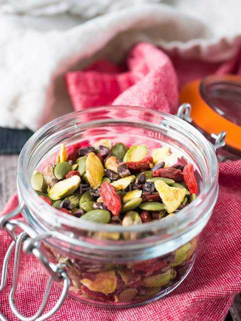 Closeup view of healthy mix of dry fruit, nuts and seeds in glass jar — Stock Photo