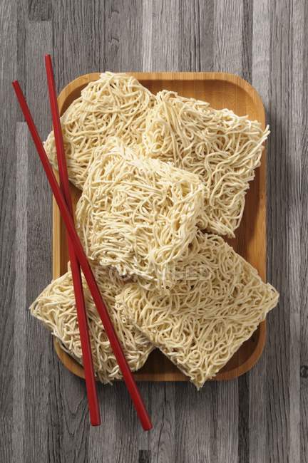 Top view of Asian noodles and red chopsticks — Stock Photo