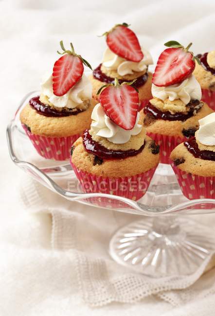 Cream cupcakes on glass cake stand — Stock Photo