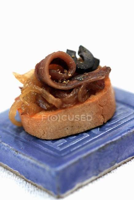 Crostini con anchoas y confit de cebolla - foto de stock