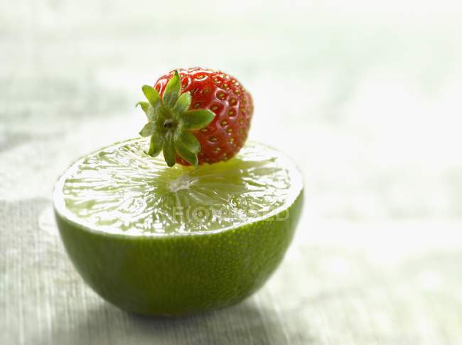 Die Hälfte frische Limetten und Erdbeeren — Stockfoto