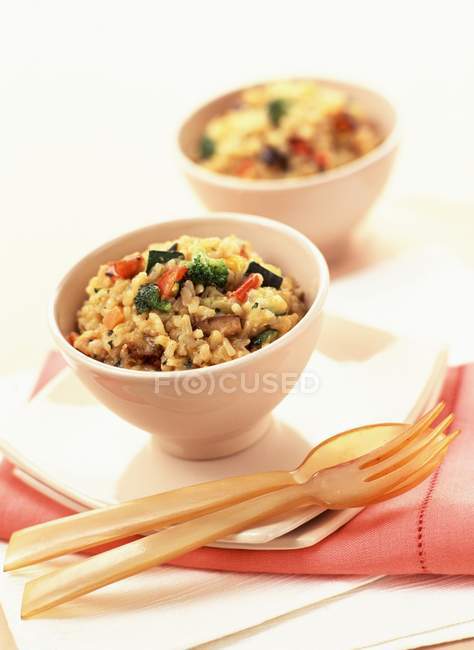 Vegetable risotto in white pots over red towel — Stock Photo