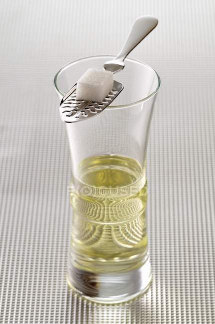 Closeup view of Absinthe with spoon and sugar lump on glass — Stock Photo