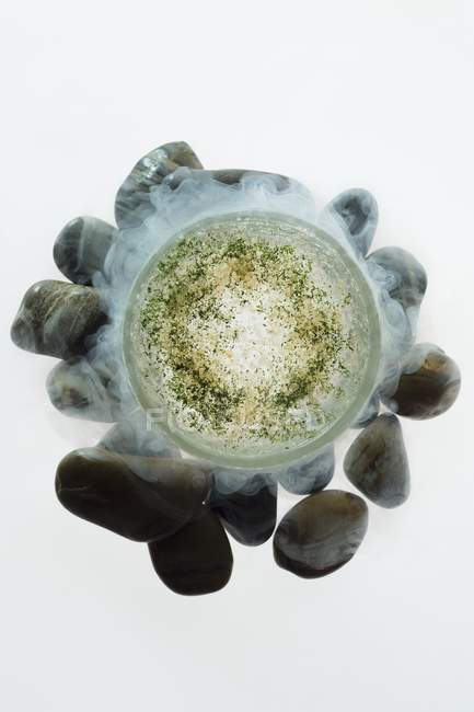 Closeup top view of frozen glass of mint drink on stones and white background — Stock Photo