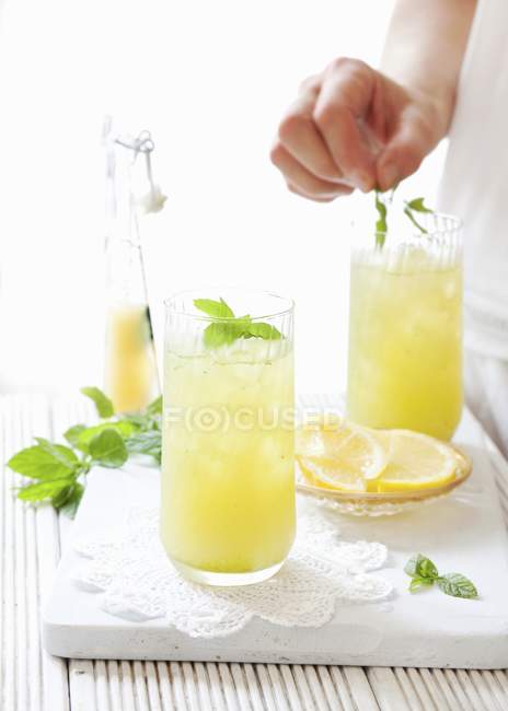 Mão humana decorando limonada de maçã — Fotografia de Stock