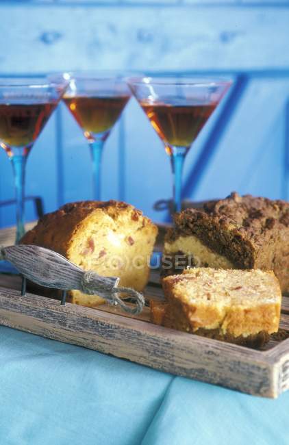Cake and glasses of aperitif on wooden tray — Stock Photo