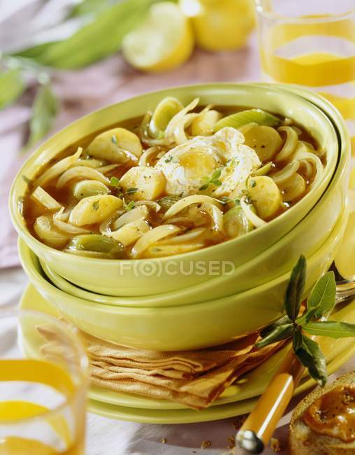 Vegetarische Bouillabaisse auf gelben Tellern über dem Tisch — Stockfoto