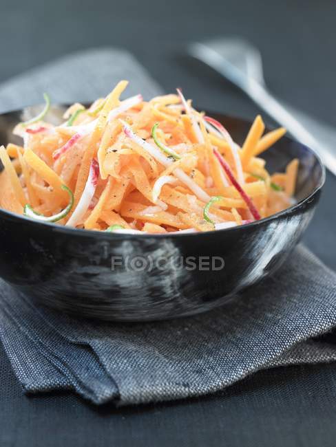 Radish salad in black bowl — Stock Photo