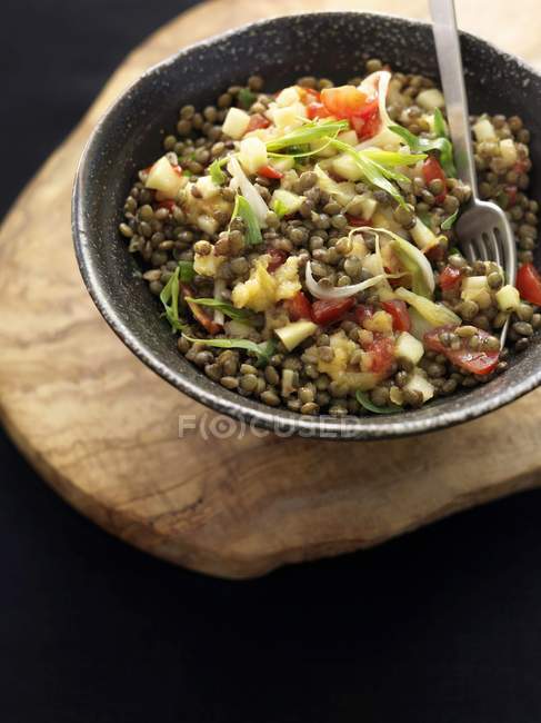 Salada de lentilha em tigela preta — Fotografia de Stock