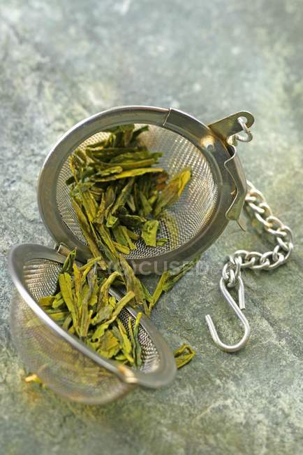 Green tea in a tea ball — Stock Photo