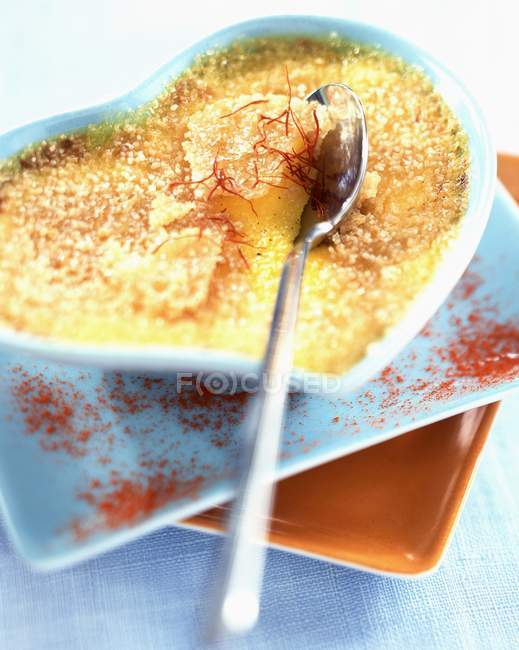 Closeup view of Creme brulee with saffron in a heart-shaped dish — Stock Photo