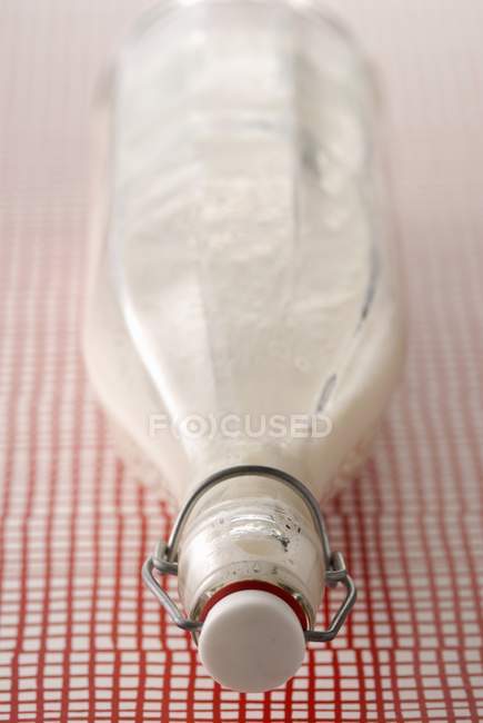 Bottle of milk over tablecloth — Stock Photo
