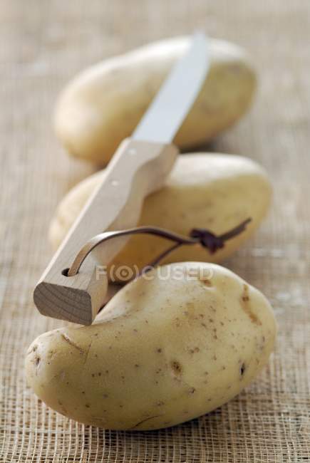 Patatas frescas y cuchillo - foto de stock