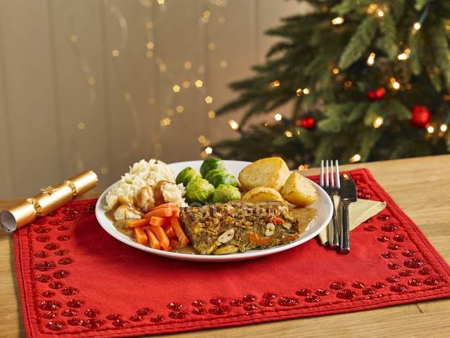 Dado arrosto cena di Natale su piatto bianco sopra asciugamano rosso — Foto stock