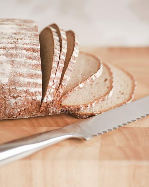 Нарезание буханки хлеба — стоковое фото