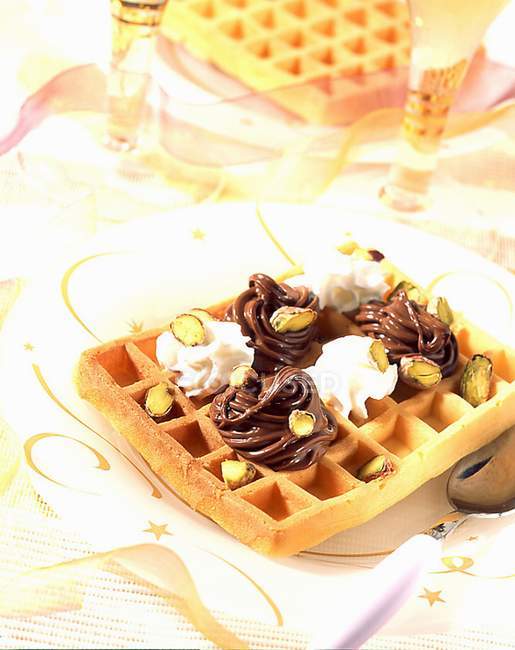 Closeup view of Harlequin waffle with pistachios and cream — Stock Photo