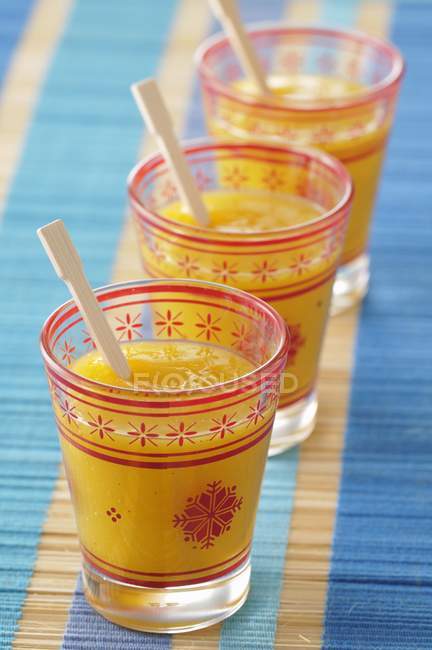 Mango soup in jars with spoons over cloth — Stock Photo