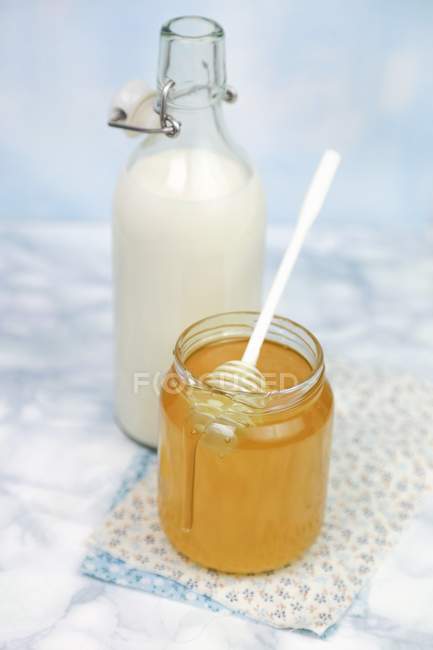 Miel dans un bocal avec cuillère — Photo de stock