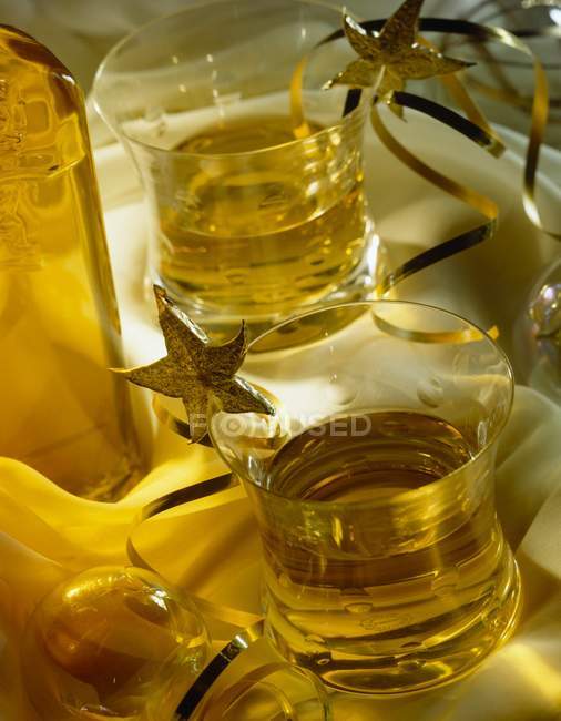Vista de cerca del whisky con rodajas de fruta estrella en vasos - foto de stock