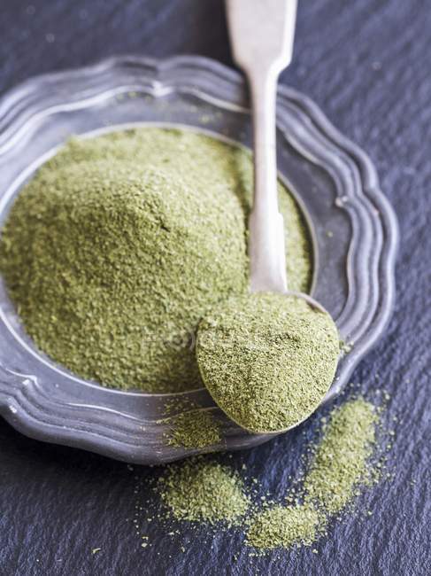 Closeup elevated view of Moringa powder on a spoon and on a plate — Stock Photo