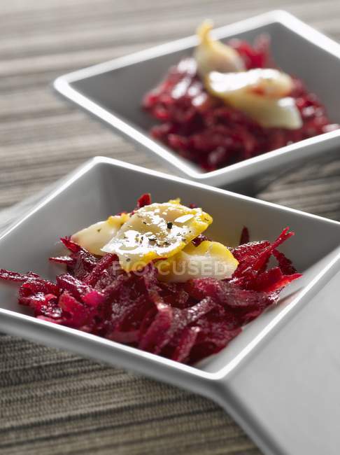Raw beetroot remoulade with raw haddock on white plates — Stock Photo