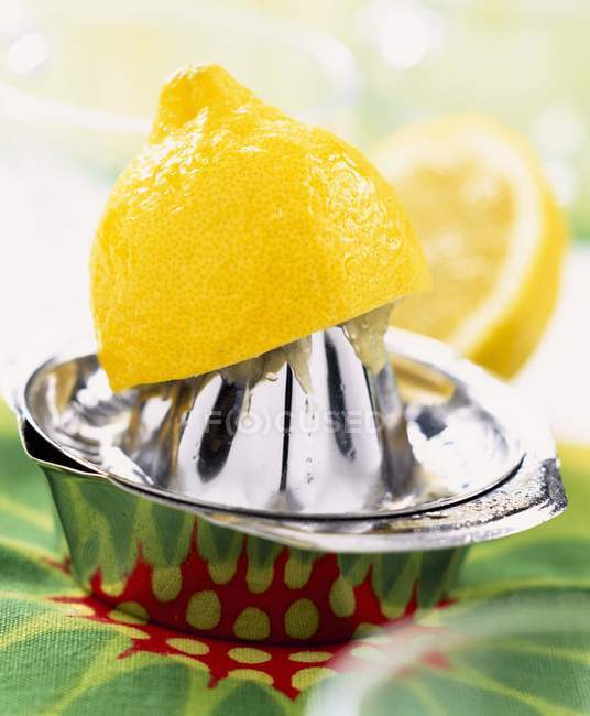 Limón fresco a la mitad y exprimidor - foto de stock