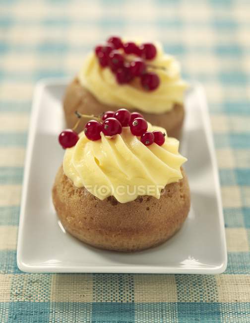 Closeup view of Cream Babas with red currants on plate — Stock Photo