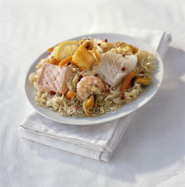 Meeresfrüchte-Choucroute auf weißem Teller über Handtuch auf Tisch — Stockfoto