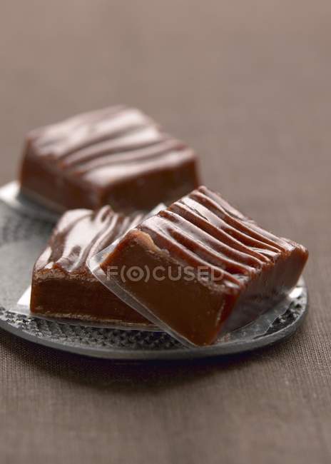 Chocolates de caramelo en el plato - foto de stock