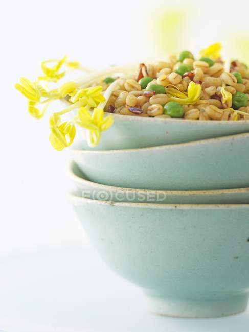 Cereais mistos com ervilhas em tigela verde na superfície branca — Fotografia de Stock