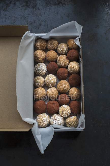 Вид сверху на энергетические шарики, прокатанные в какао, кокосовые хлопья и коричный сахар — стоковое фото