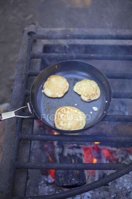Crêpes dans la casserole sur la grille de feu — Photo de stock