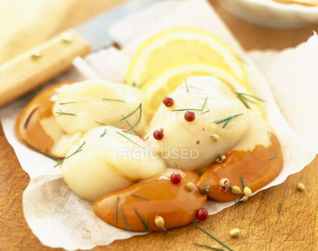 Крупним планом сирі гребінці з перцем і кропом на обробній дошці — стокове фото