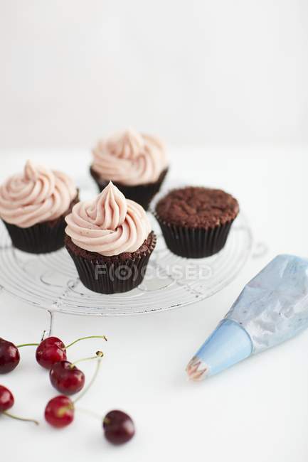 Chocolate cupcakes with cherry icing — Stock Photo