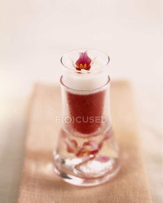 Vista de primer plano de la bebida con fresa, cocos y orquídea - foto de stock