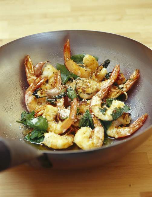Closeup view of shrimps and basil cooking with oil in wok — Stock Photo