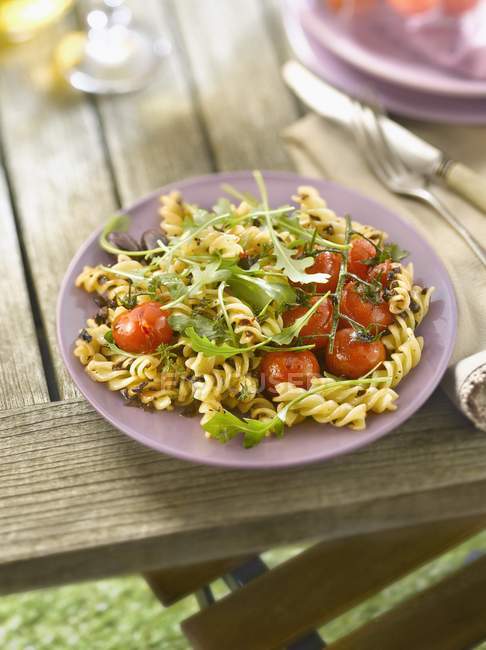 Fusilli pasta with cherry tomatoes and arugula — Stock Photo
