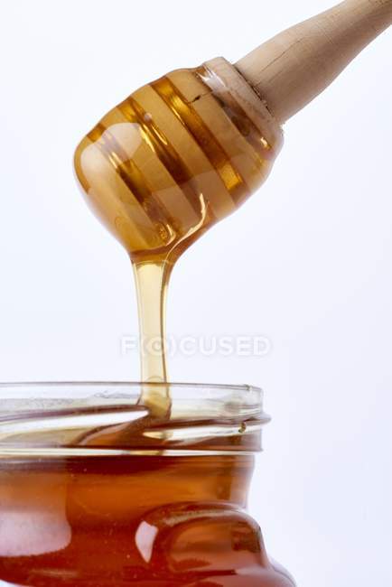 Мед течет в стекло — стоковое фото