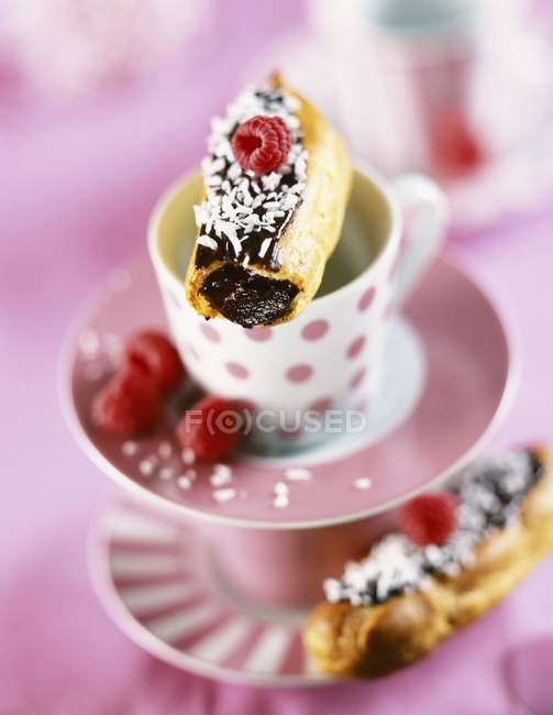 Chocolate mousse eclairs on decorated tea cups — Stock Photo