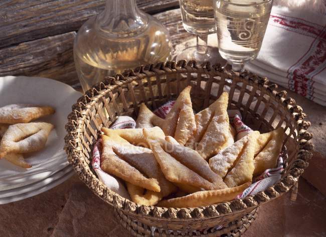 Vue surélevée de la pâtisserie traditionnelle sucrée et croustillante Bugnes dans un bol en osier — Photo de stock
