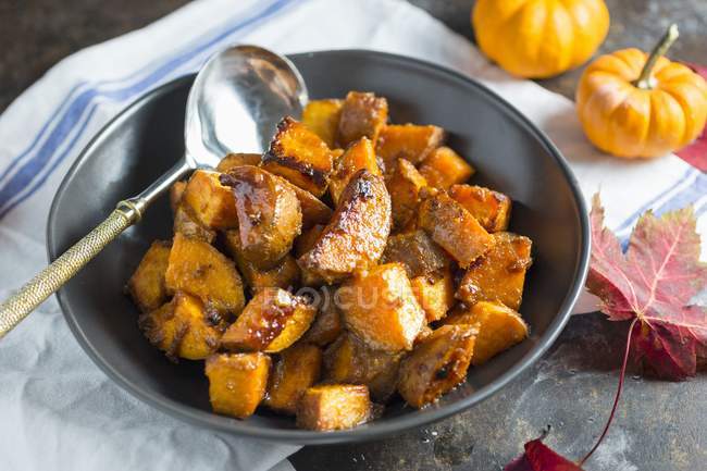 Maple Roasted with Sweet Potatoes in black platter with ladle — Stock Photo