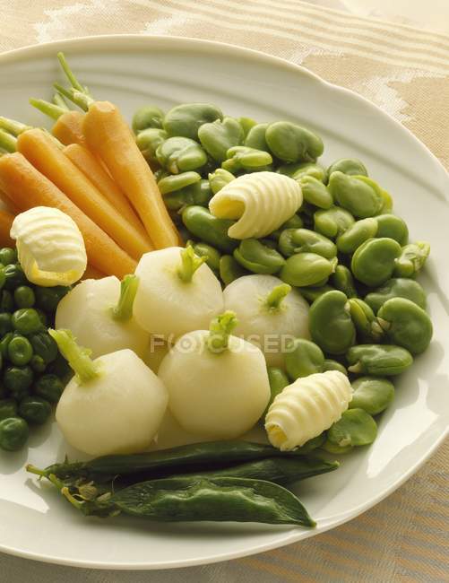 White Plate of vegetables over textile surface — Stock Photo