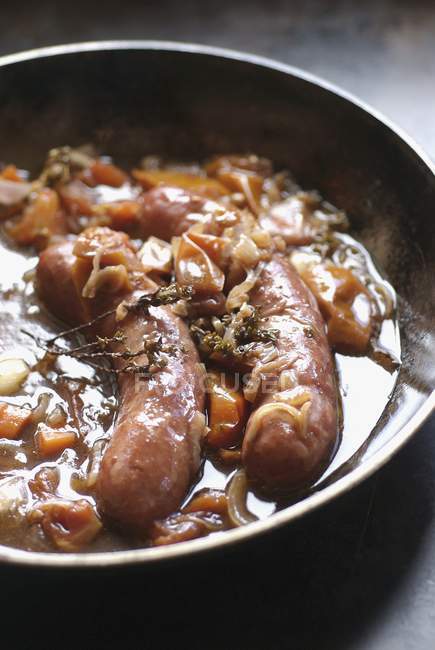 Stewed sausages with onion and carrots — Stock Photo