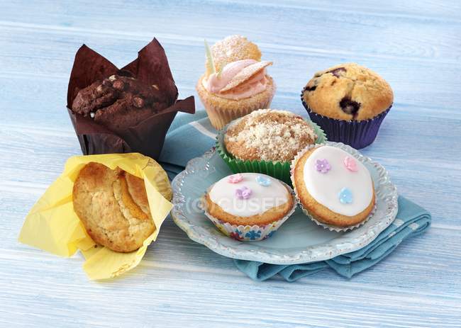Cupcakes e Muffins em uma superfície azul — Fotografia de Stock