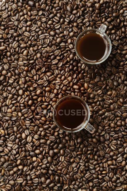 Granos de café y tazas - foto de stock