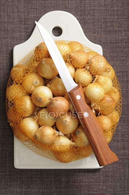 String bag of small onions — Stock Photo