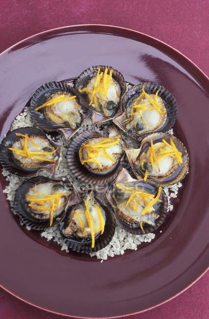 Scallops with mandarin on plate — Stock Photo